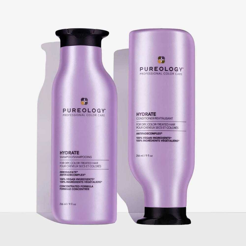 Two bottles of Pureology hair care products against a white background.