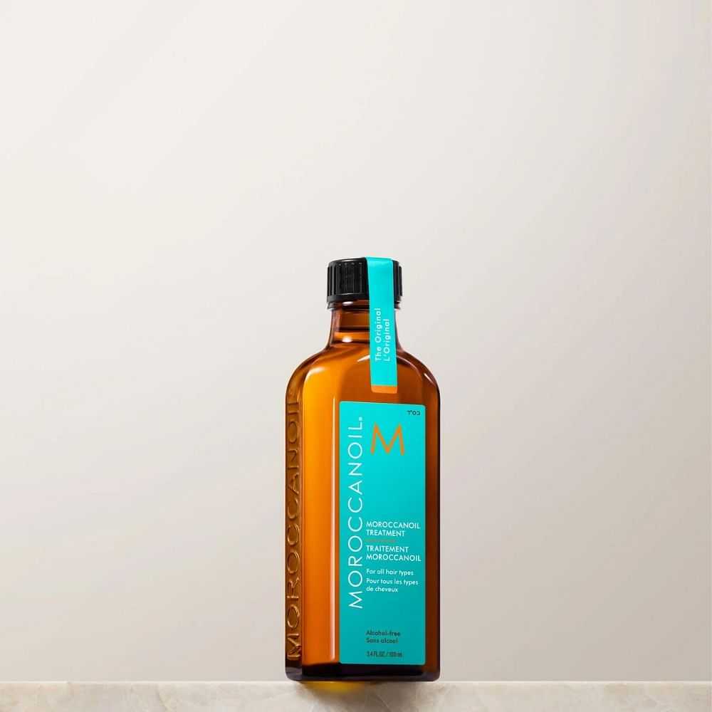 Bottle of Moroccanoil Treatment on a beige background.