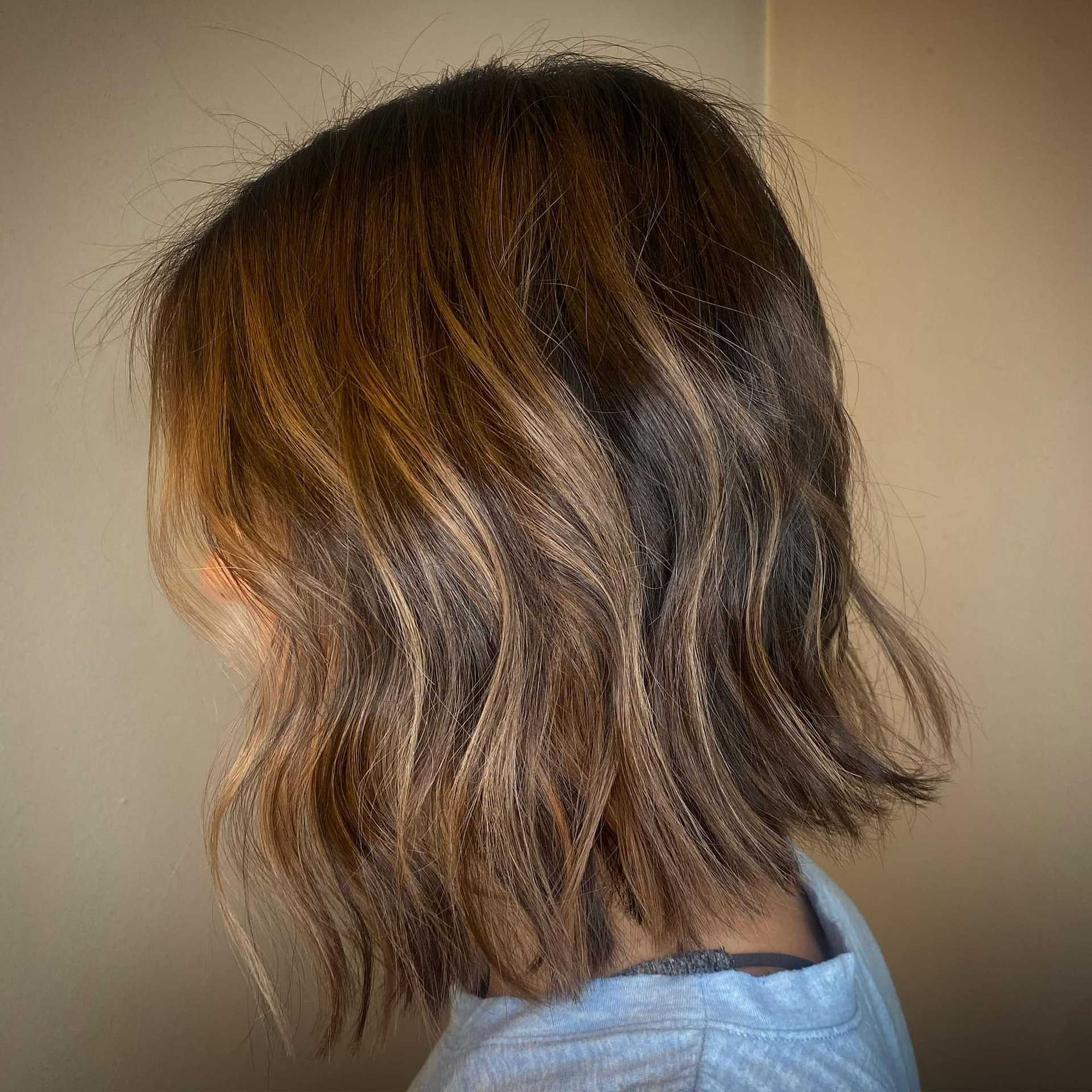 Person with a stylish short wavy brown ombre hairstyle.