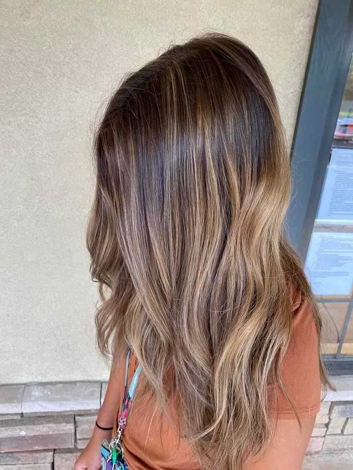 Woman showing her balayage hairstyle from the back.