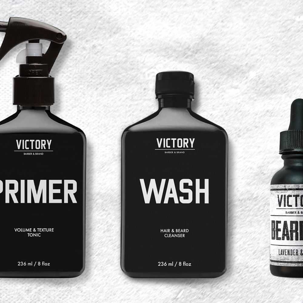 Three bottles of men's grooming products labeled Primer, Wash, and Beard Oil.