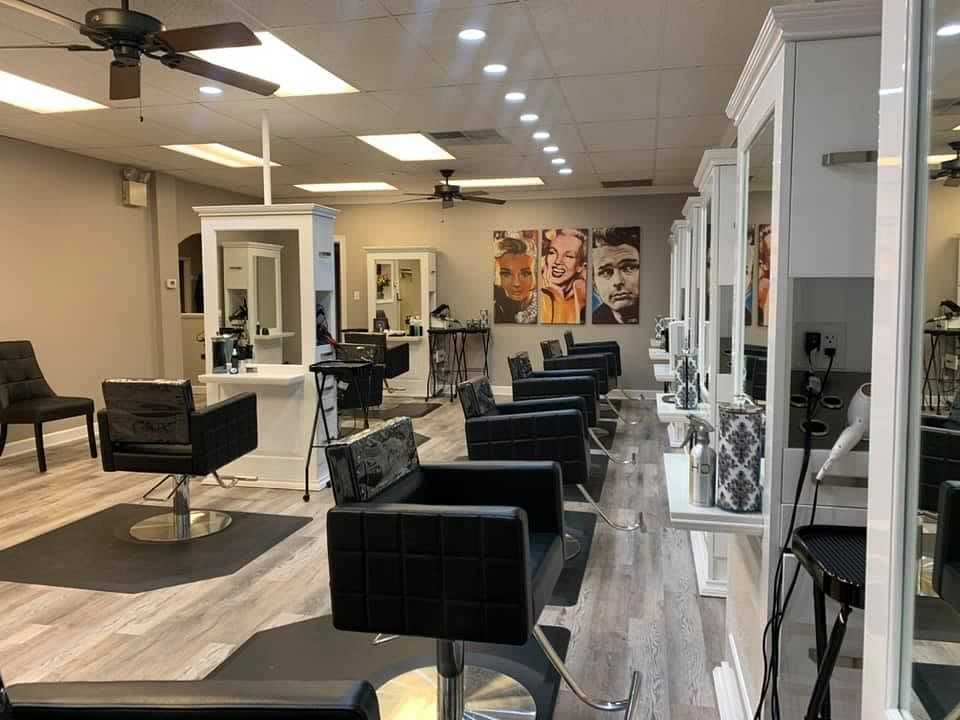 Interior of a modern hair salon with chairs, mirrors, and styling stations.